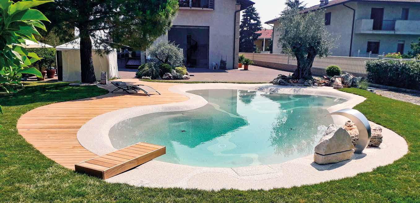 Piscina de arena Bio.design en jardín residencial con olivo